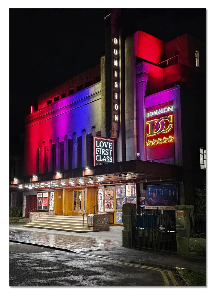 The Dominion Cinema in Morningside at night with neon light reflecting on wet streets, fine art photography print.