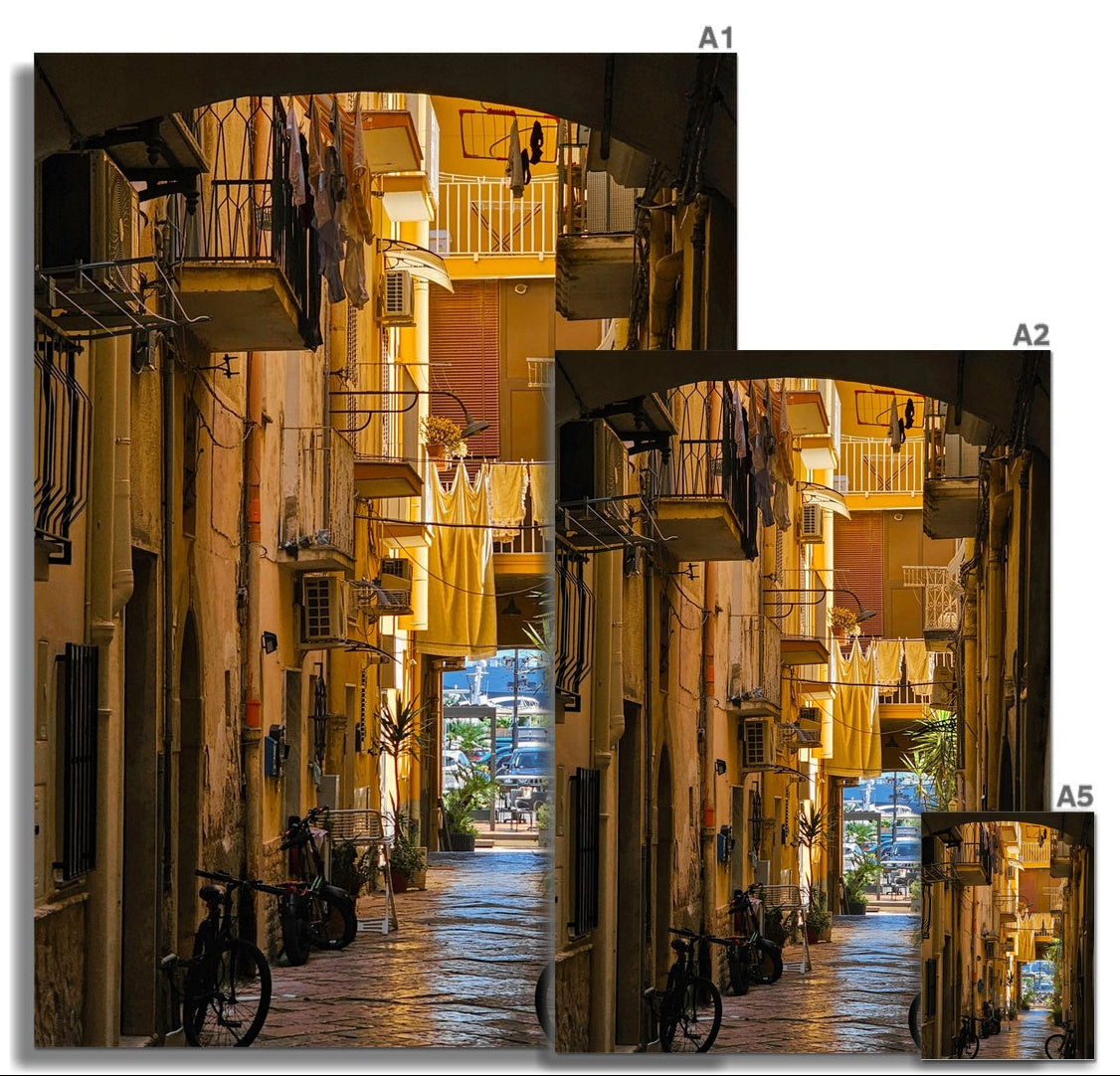 Verso il Mare fine art photograph looking along a narrow Italian street towards the sea, framed by balconies and bicycles