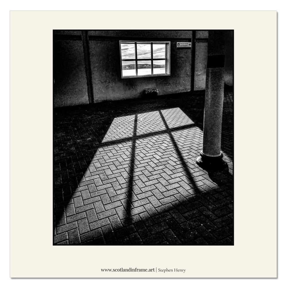 Contemporary photograph of the view through a rectangular window as the Sun was rising. Throwing light onto a brick floor.